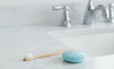 Electric toothbrush and clear retainer case on a bathroom counter