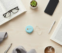 Flatlay of aligner case and clear aligners with lifestyle items