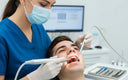 Dental hygienist performing deep cleaning with ultrasonic scaler on patient’s teeth