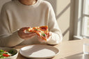 Person enjoying pizza with a clear retainer safely stored in a case beside the plate