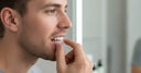 Individual placing clear aligners on teeth at home