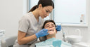 Dentist examining teeth and retainer during routine orthodontic check-up