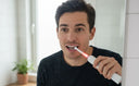 Adult using electric toothbrush with pressure sensor to protect bleeding gums