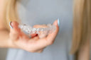 Person holding guard between fingers with close-up focus.