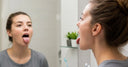Individual performing myofunctional exercises to support teeth alignment