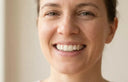 Photorealistic close-up of an adult smiling confidently, showing subtle teeth alignment