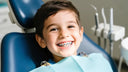Child smiling in dental chair and showing braces on teeth