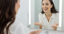 Woman checking her straightened teeth in the mirror after wearing clear aligners