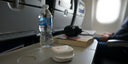 Clear aligner case on a travel bag or airport tray table.
