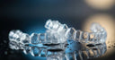 Crystal-clear aligner tray on a reflective surface