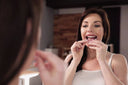 A women infront of the mirror, putting the cl;ear braces