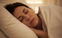 Person sleeping while experiencing nighttime teeth grinding (bruxism).