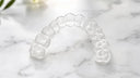 Single clear dental retainer for upper arch on white surface — NewSmile USA single arch retainer option for top or bottom teeth protection