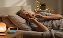 Older man relaxing before sleep, gently touching jaw with calm expression — soft bedside lighting.