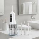White dental water flosser with multiple nozzles on a bathroom counter.
