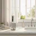 White and clear water flosser on a bathroom counter with a window in the background
