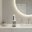 White dental water flosser on a bathroom counter with a mirror and sink in the background.